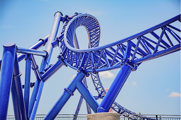 Get a closer look at the roller coaster track at COTALAND™. Discover the intricacies of its blue structure against the backdrop of the sky.